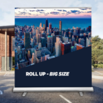 big roll-up banner with full colour print standing on the car park in front of the building
