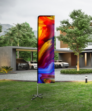 winder flag with full colour print standing on the lawn in front of the house